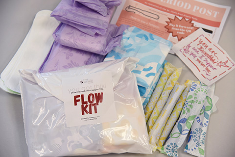 A white package with Flow Kit in red text on top of various period supplies grouped together