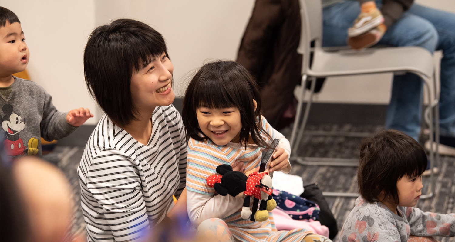 Asian mother and child enjoying a library program