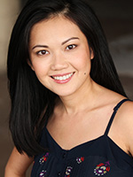 Doan Phuong Nguyen smiling with her black hair down over one shoulder and wearing a dark top with spaghetti straps