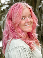 Samantha Markum outdoors looking over her right shoulder with her pink hair down