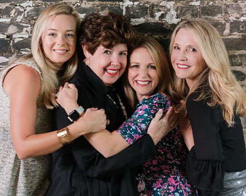 Color photo of Mary Kay Andrews, Kristin Harmel, Patti Callahan Henry & Kristy Woodson Harvey all hugging