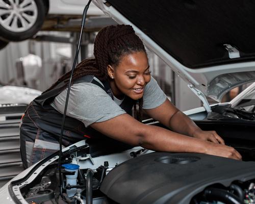 African American woman working under the hood of a car