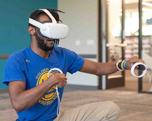 African American person using a VR head set in the library